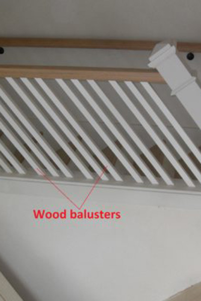 Staircase image of balusters with red text pointing to wood balusters