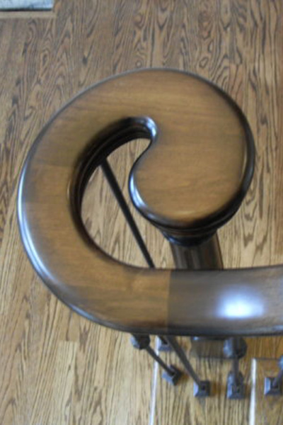 Image of an alder wood volute at bottom of staircase railing
